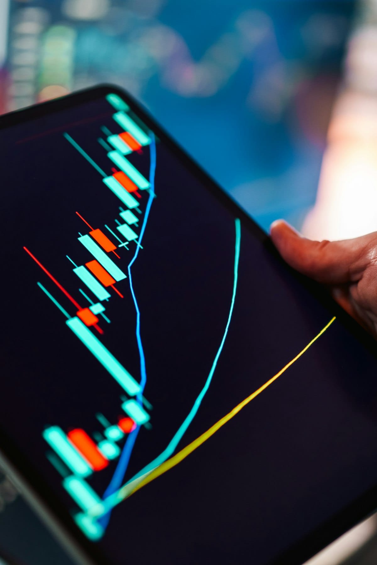Hand holding tablet showing market data